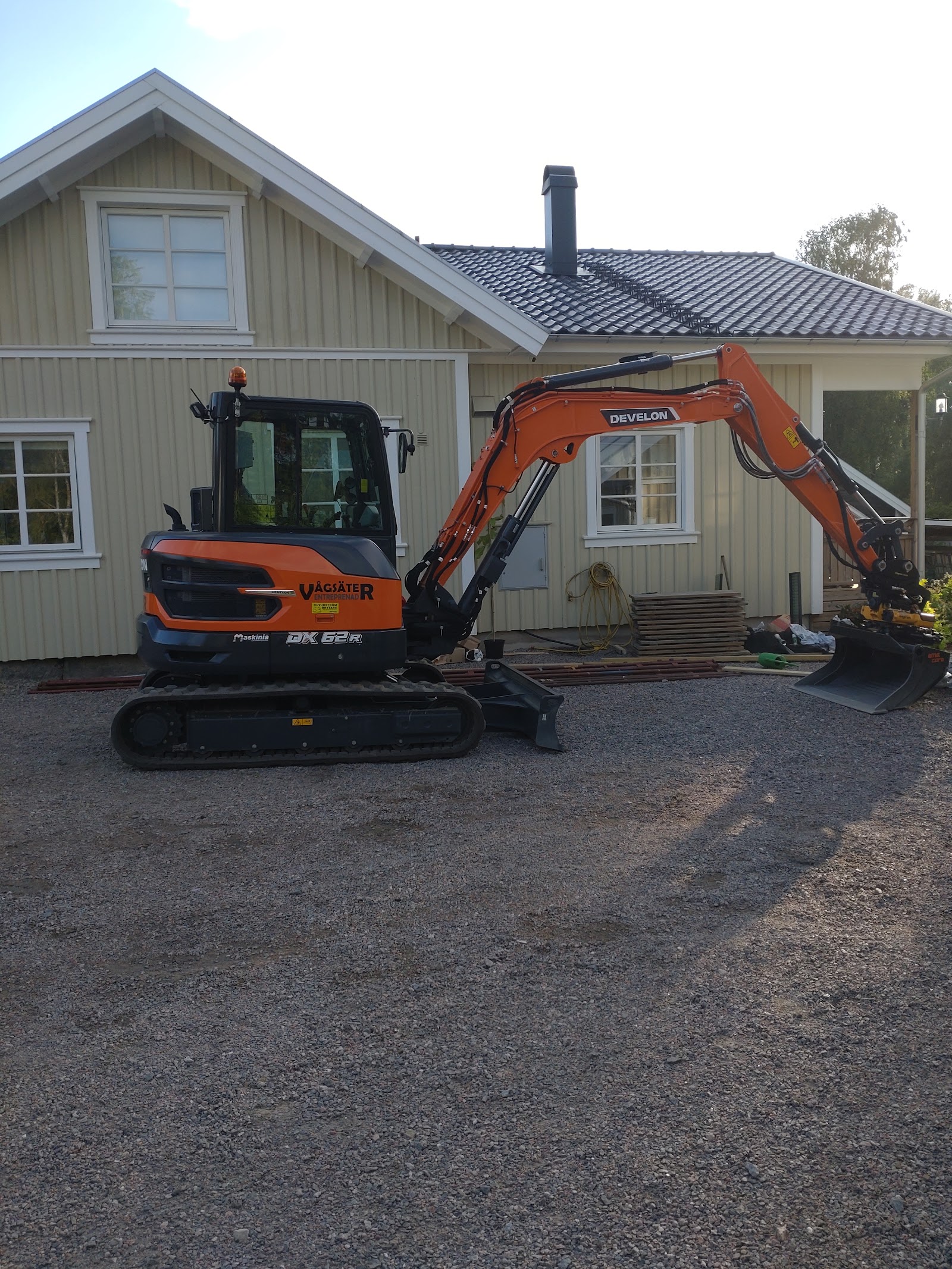 Grävmaskin framför villa