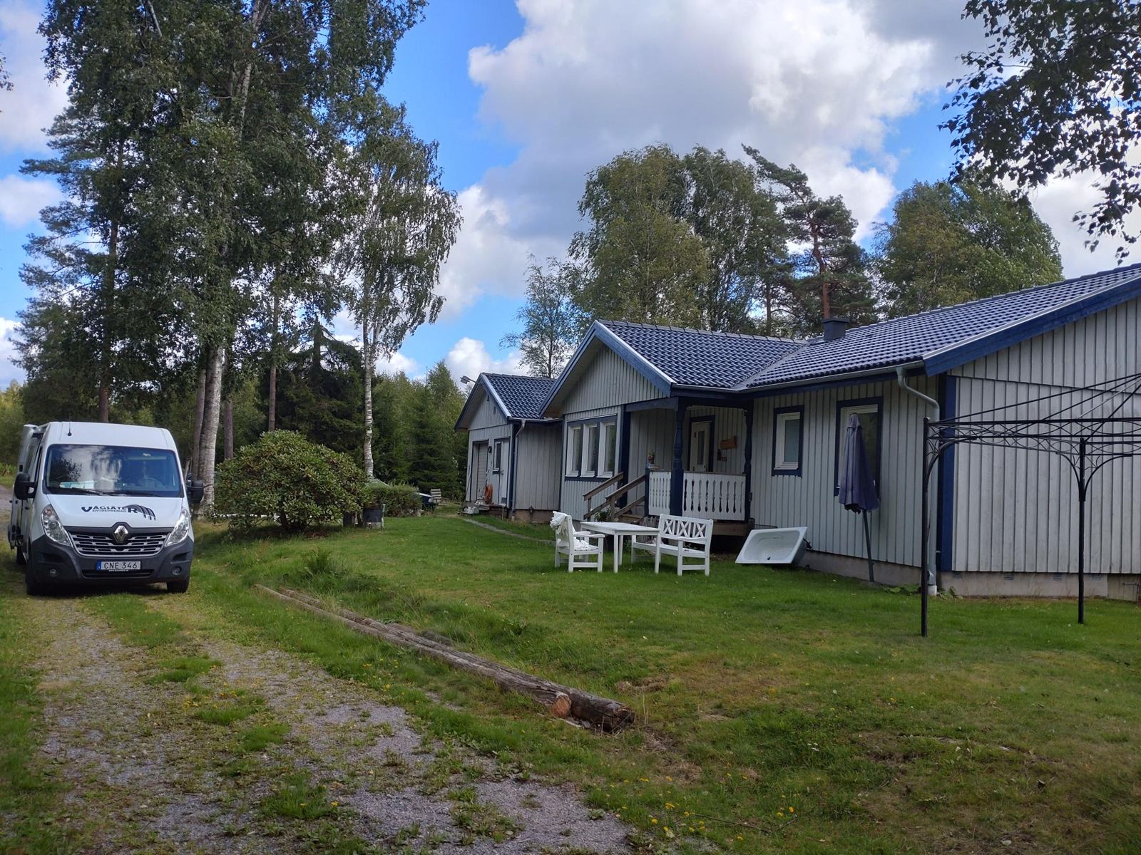 Villa med nytt blått tegeltak och firmabilen på tomten
